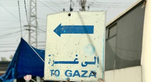 a sign pointing to the right in front of a bus